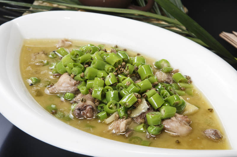 叶子型瓷盘装的酸汤米椒鸡块图片