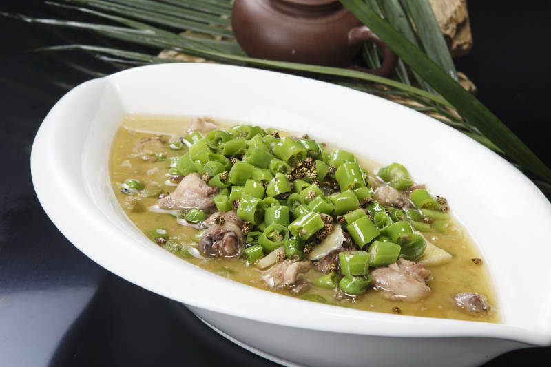 叶子型瓷盘装的酸汤米椒鸡块图片