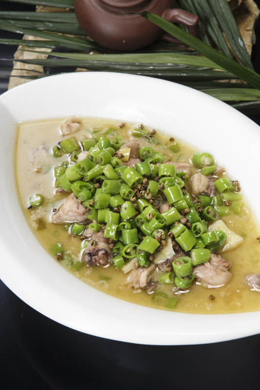 叶子型瓷盘装的酸汤米椒鸡块图片