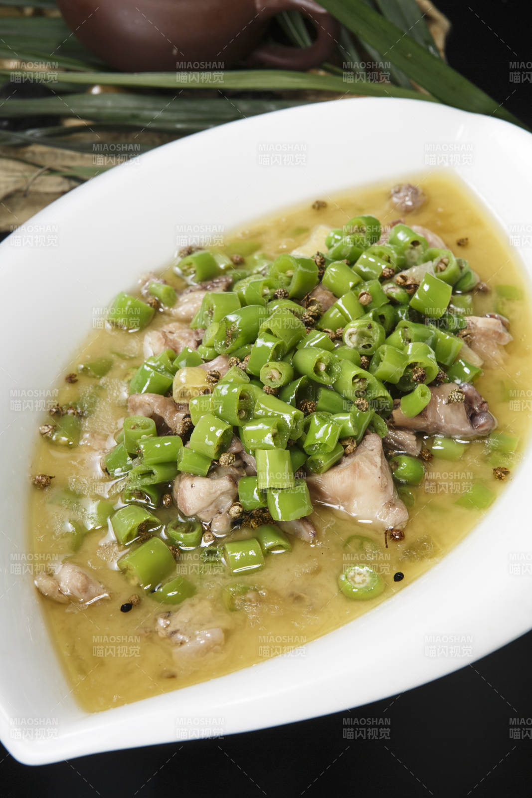 叶子型瓷盘装的酸汤米椒鸡块图片