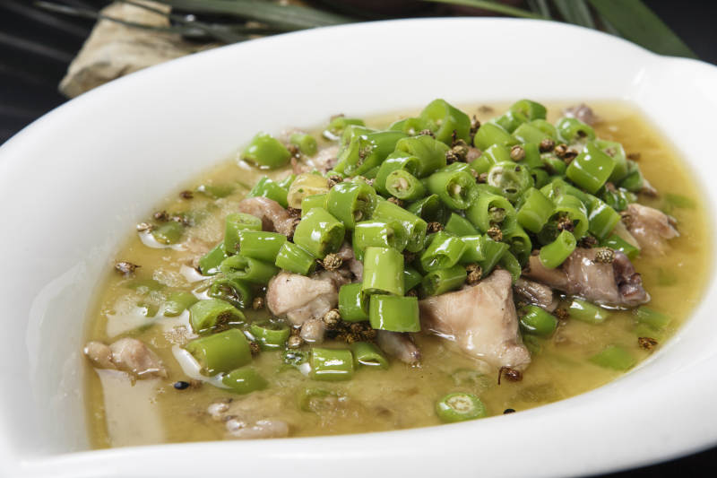 叶子型瓷盘装的酸汤米椒鸡块图片