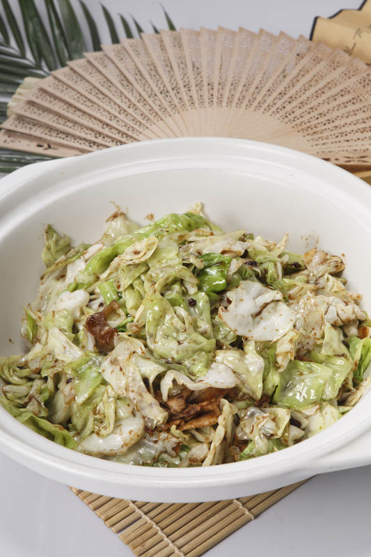 寿司帘上的白色砂锅装的油渣爆包菜图片