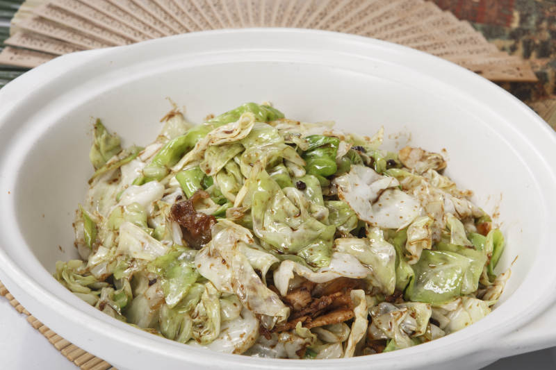 寿司帘上的白色砂锅装的油渣爆包菜图片