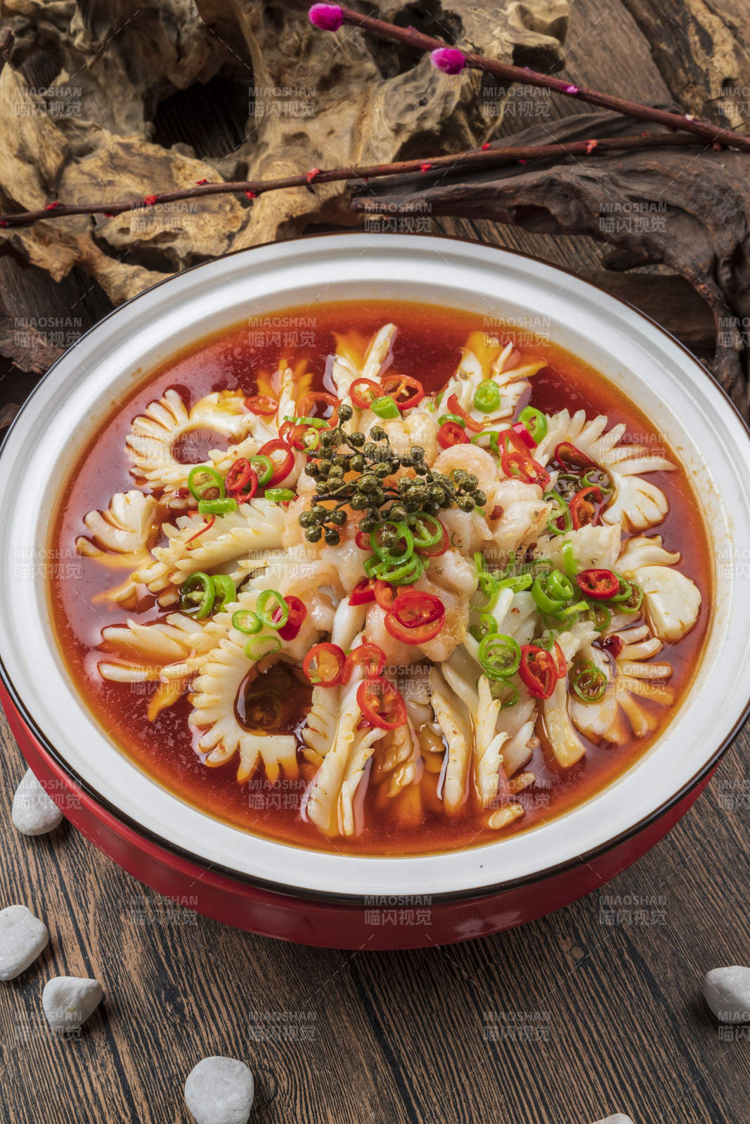 白色圆瓷盘装的椒麻红油鱿鱼卷图片