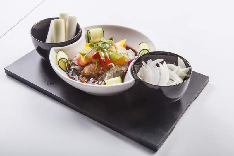 白色瓷盘装的酸辣海蜇皮图片