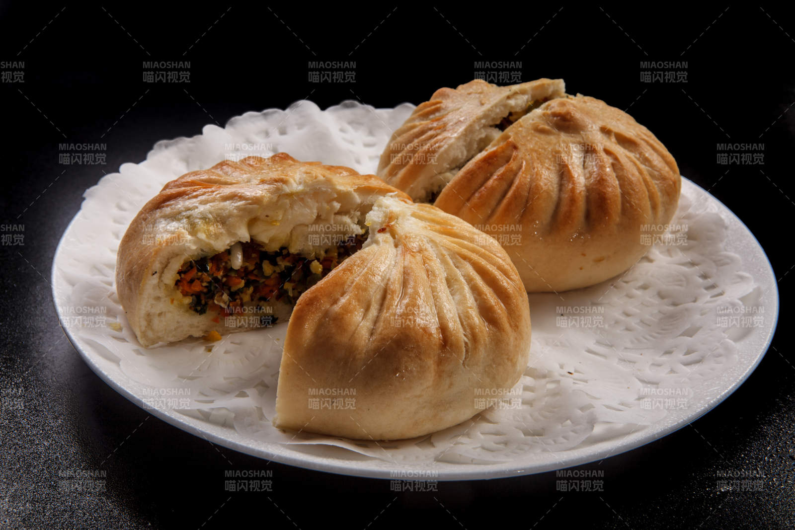 白色瓷盘装的美味烤包子图片