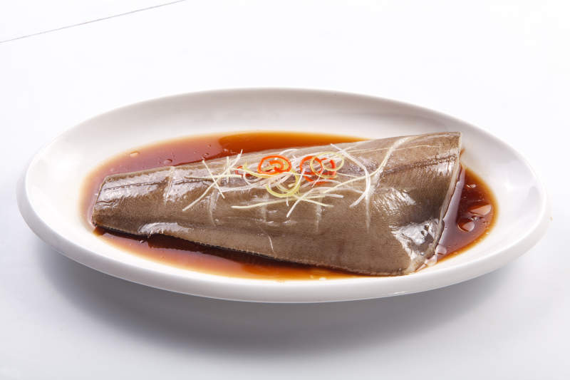 白色瓷盘装的浇汁清蒸鲽鱼尾图片