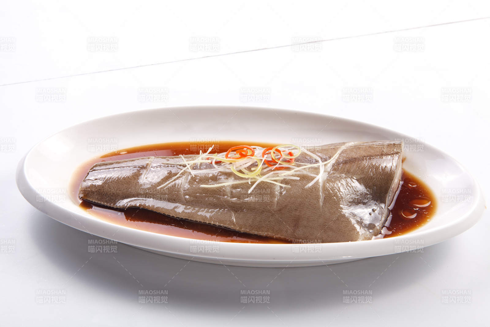 白色瓷盘装的浇汁清蒸鲽鱼尾图片