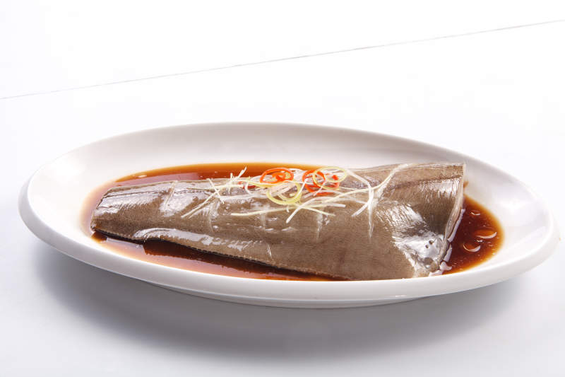 白色瓷盘装的浇汁清蒸鲽鱼尾图片