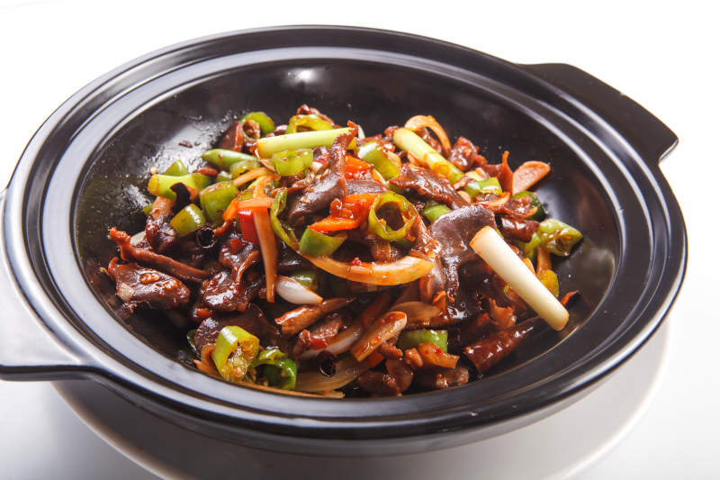 白色背景上的砂锅香辣鸡胗图片