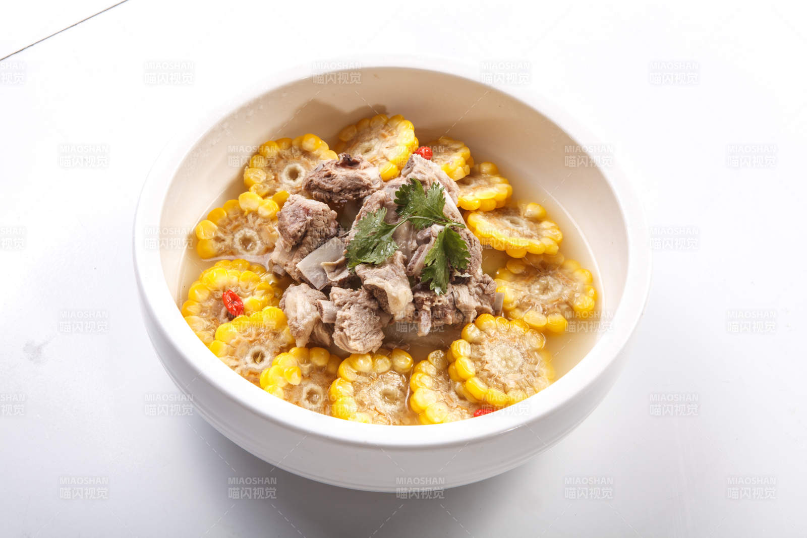 白色瓷盘装的清汤玉米炖猪排图片