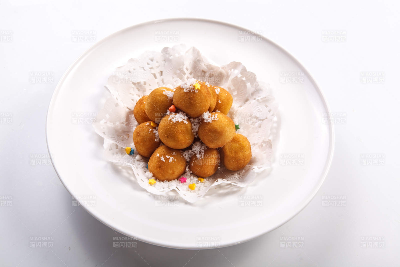 白色瓷盘装的撒糖油炸汤圆图片