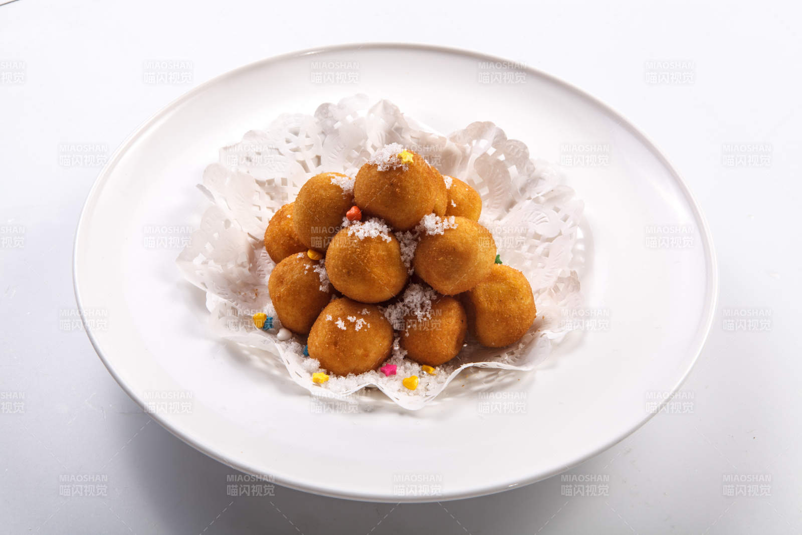白色瓷盘装的撒糖油炸汤圆图片