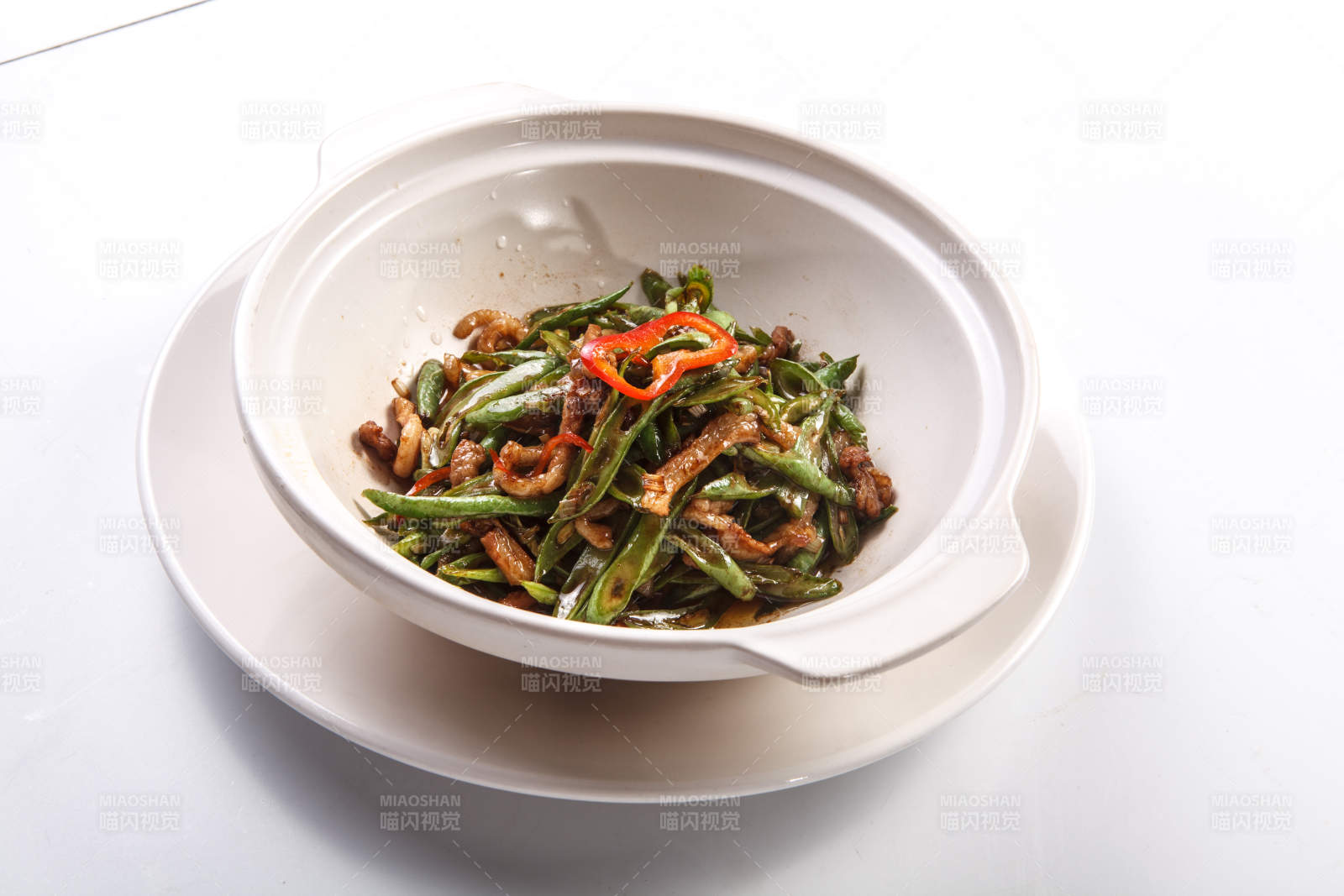 白色背景上的砂锅酱爆豆角肉丝图片