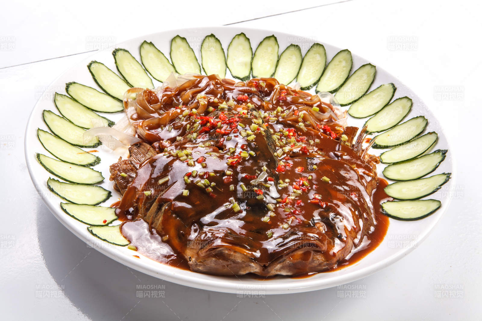 白瓷盘装的酱焖千岛湖大鱼头图片