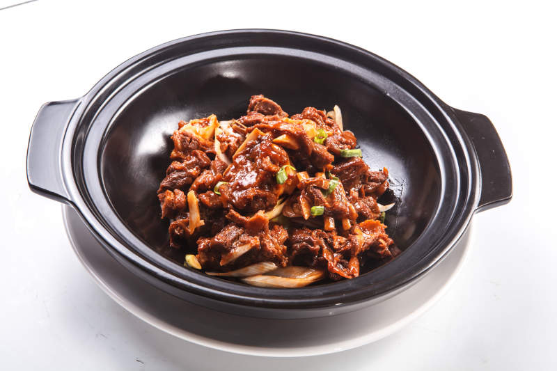 白色背景上的砂锅猪腩肉图片