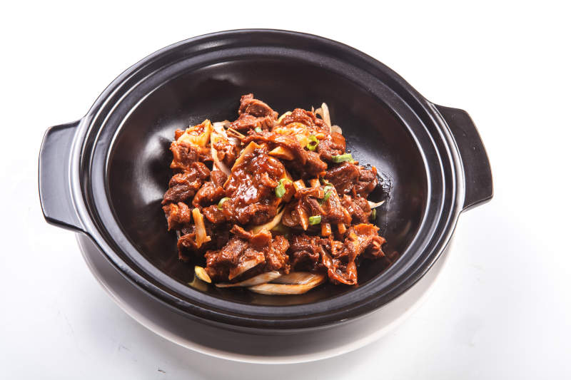 白色背景上的砂锅猪腩肉图片