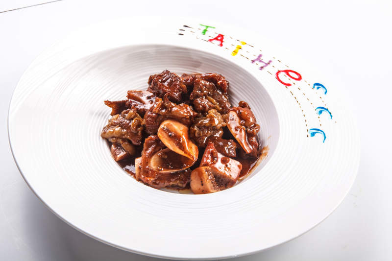 白色瓷盘装的酱焖牛仔骨图片
