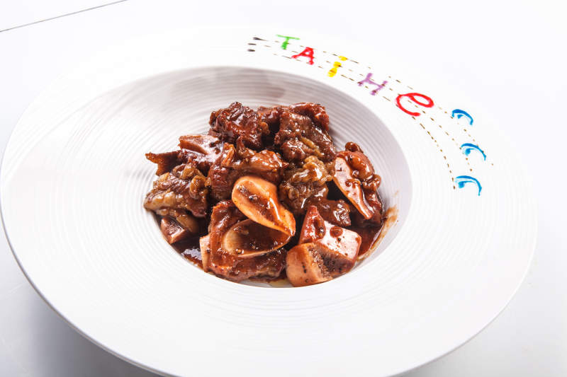白色瓷盘装的酱焖牛仔骨图片