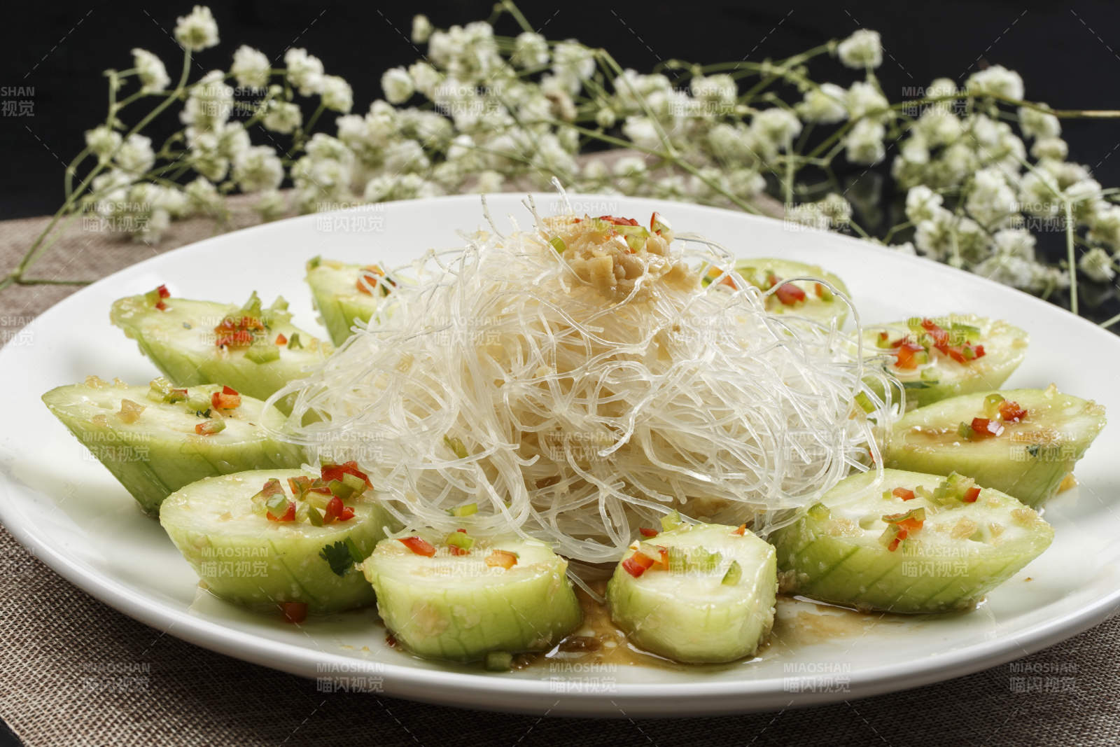 白色瓷盘装的蒜蓉粉丝蒸蒸青瓜图片