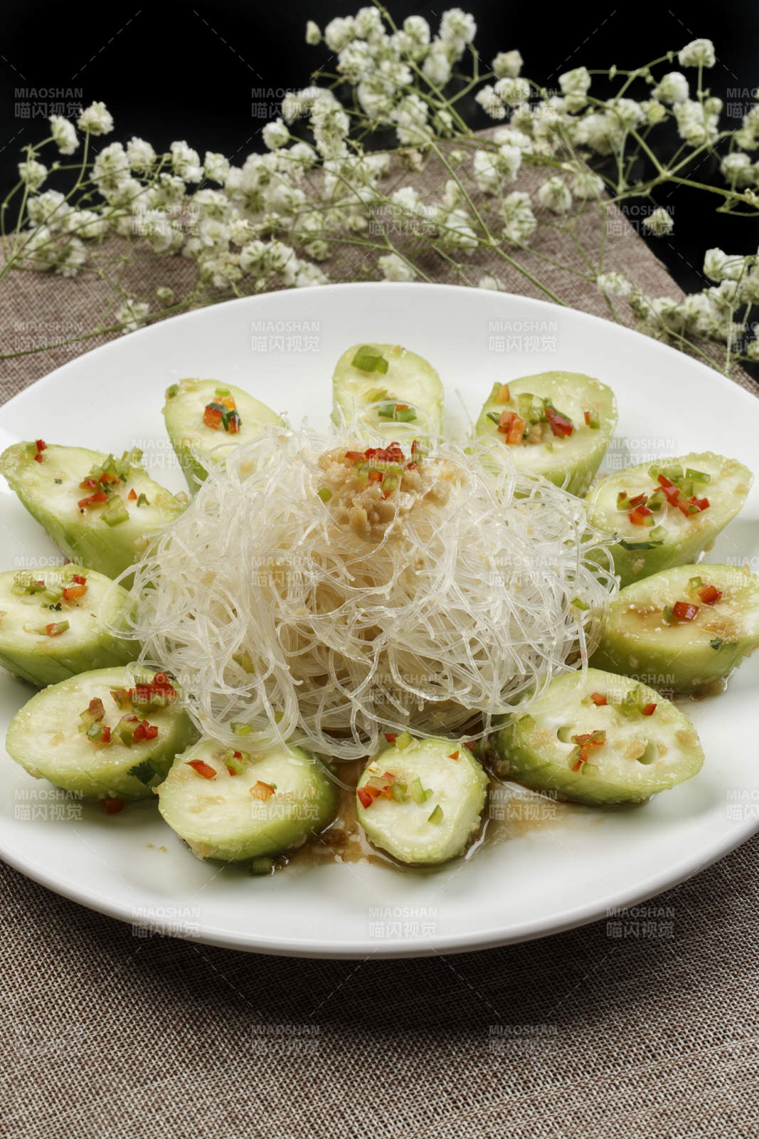 白色瓷盘装的蒜蓉粉丝蒸蒸青瓜图片