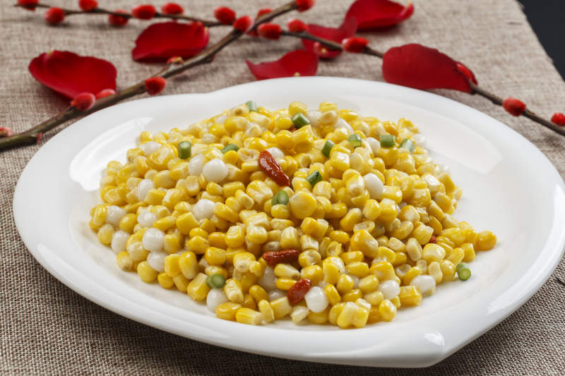 白色瓷盘装的松仁玉米图片