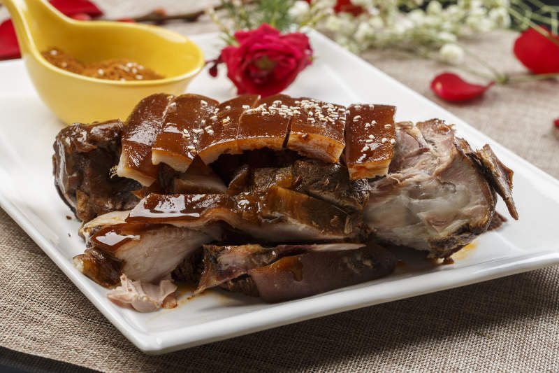 白色瓷盘装的脆皮烤猪肘图片