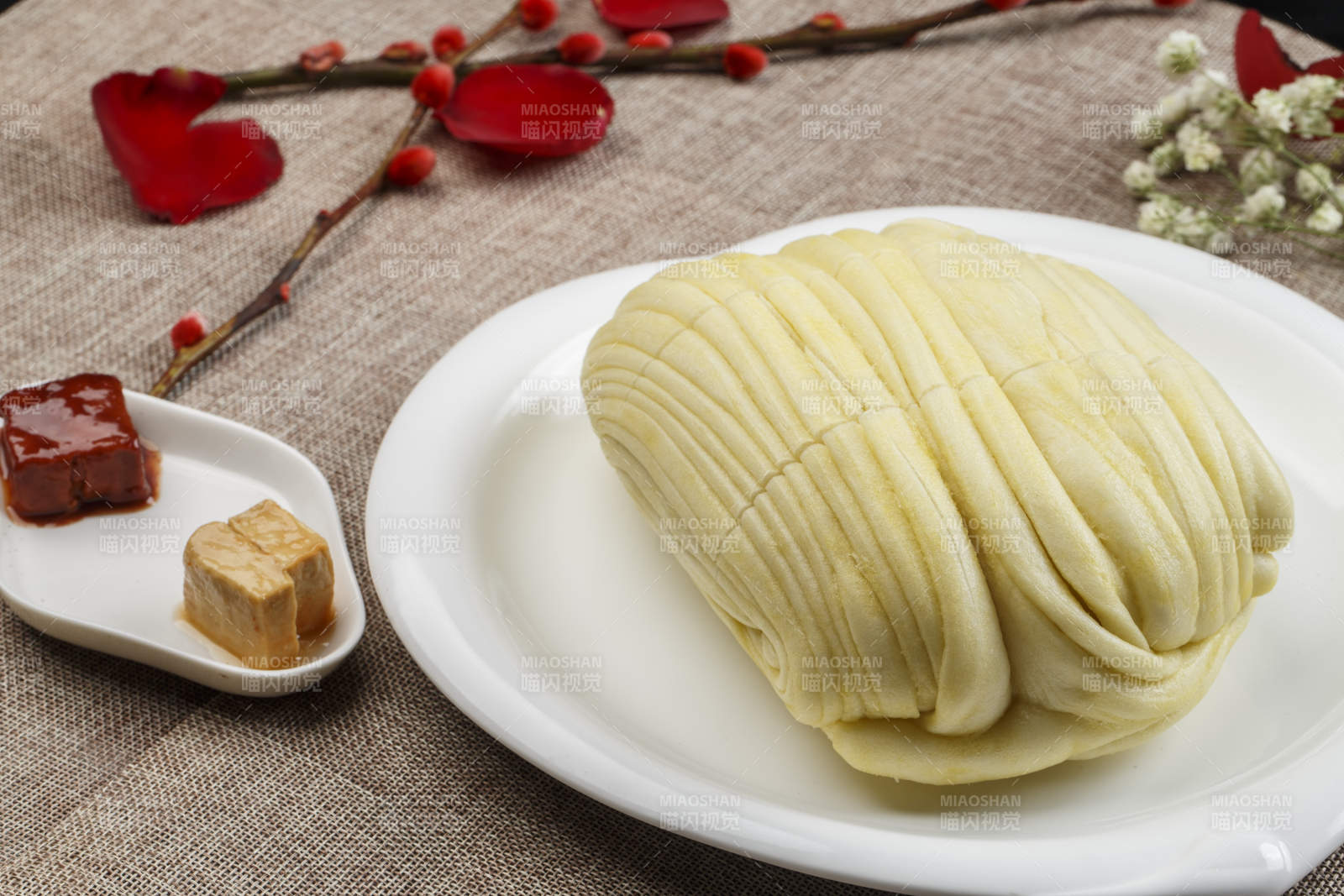 白色瓷盘装的现蒸麻油大花卷图片