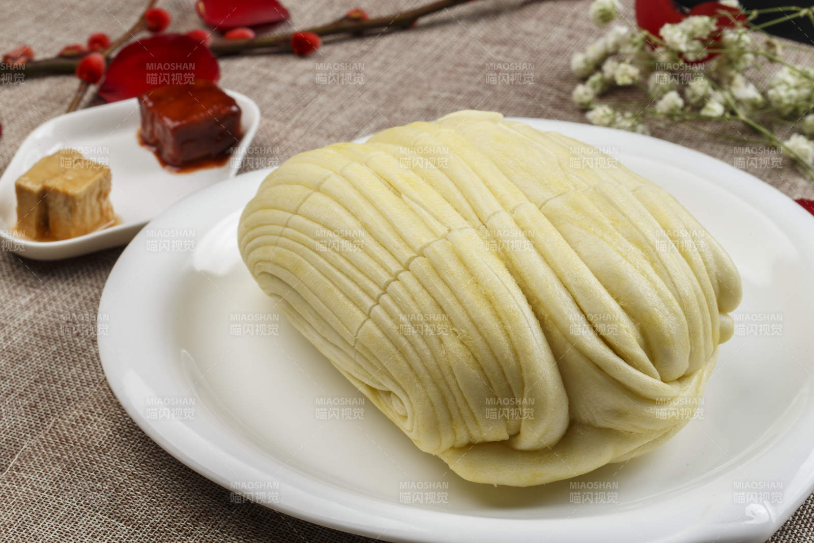 白色瓷盘装的现蒸麻油大花卷图片