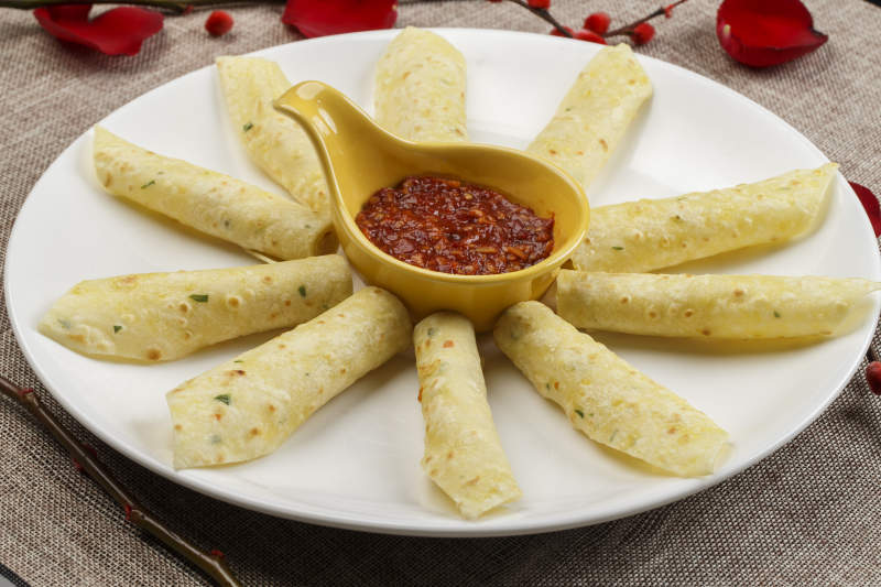 白色瓷盘装的蘸酱玉米饼图片