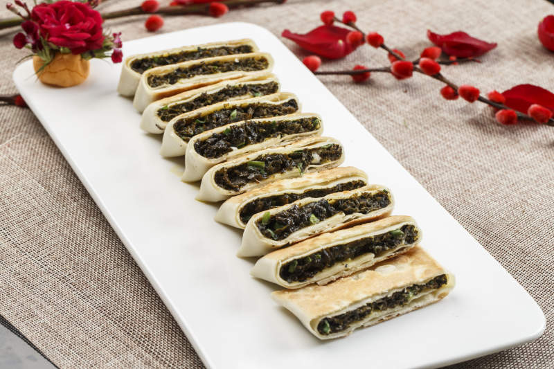 白色瓷盘装的鸡蛋野菜馅馅饼图片