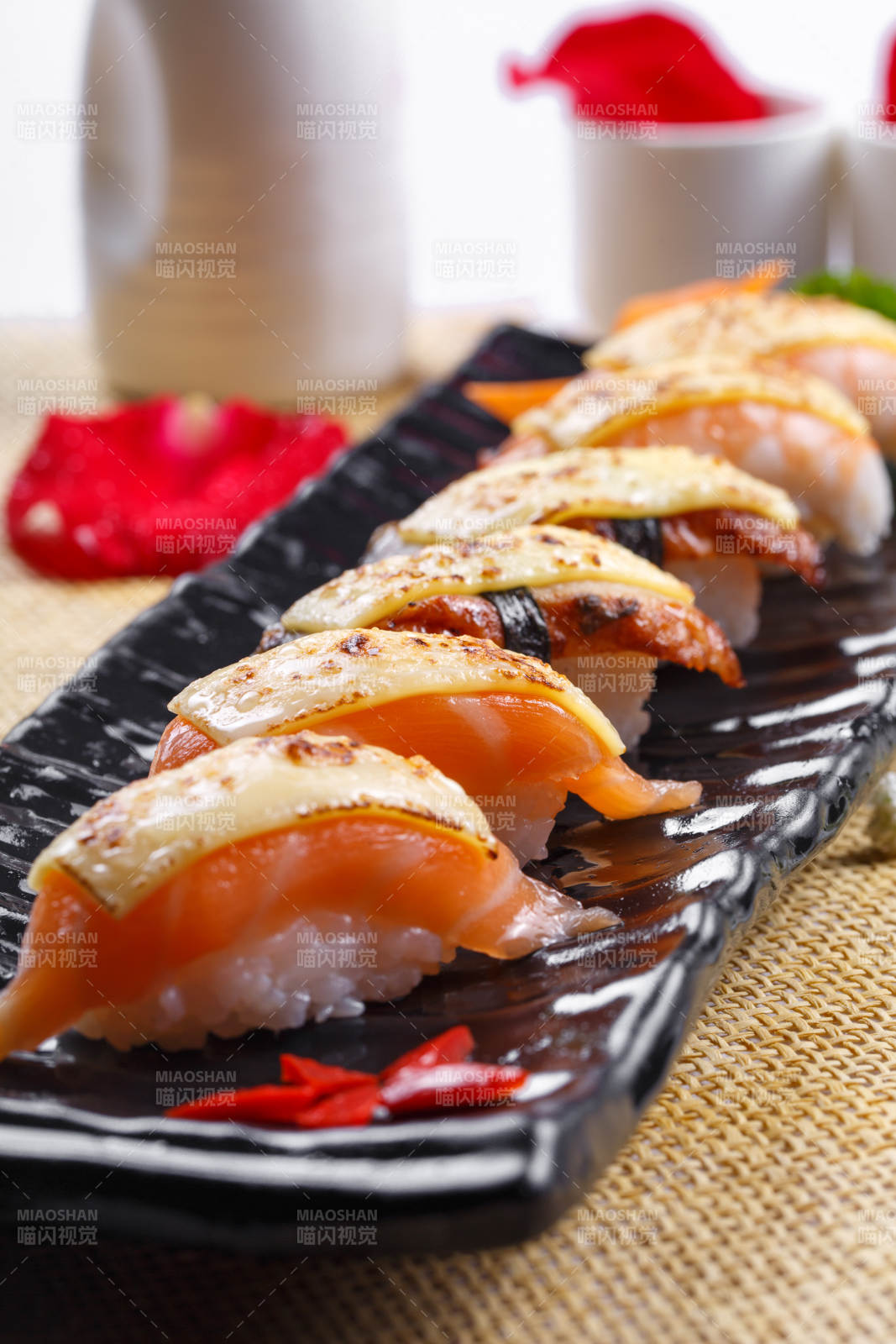 芝士焗三文鱼手握寿司摆放在草垫上图片