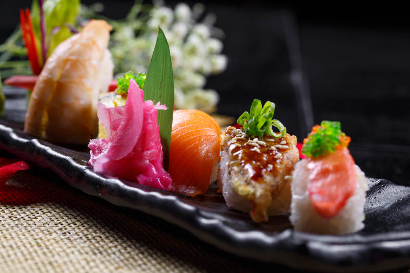 精美餐具装的高级手握寿司拼盘图片
