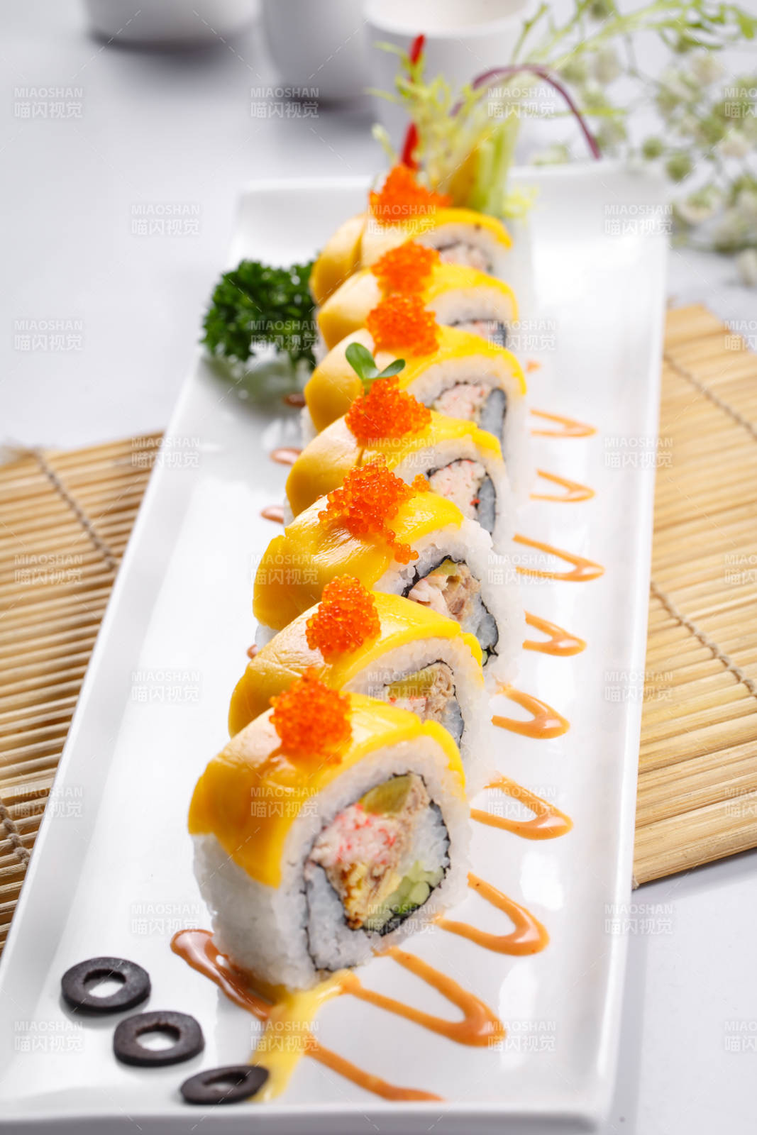 黄金甲蟹子寿司卷摆放在寿司帘上图片