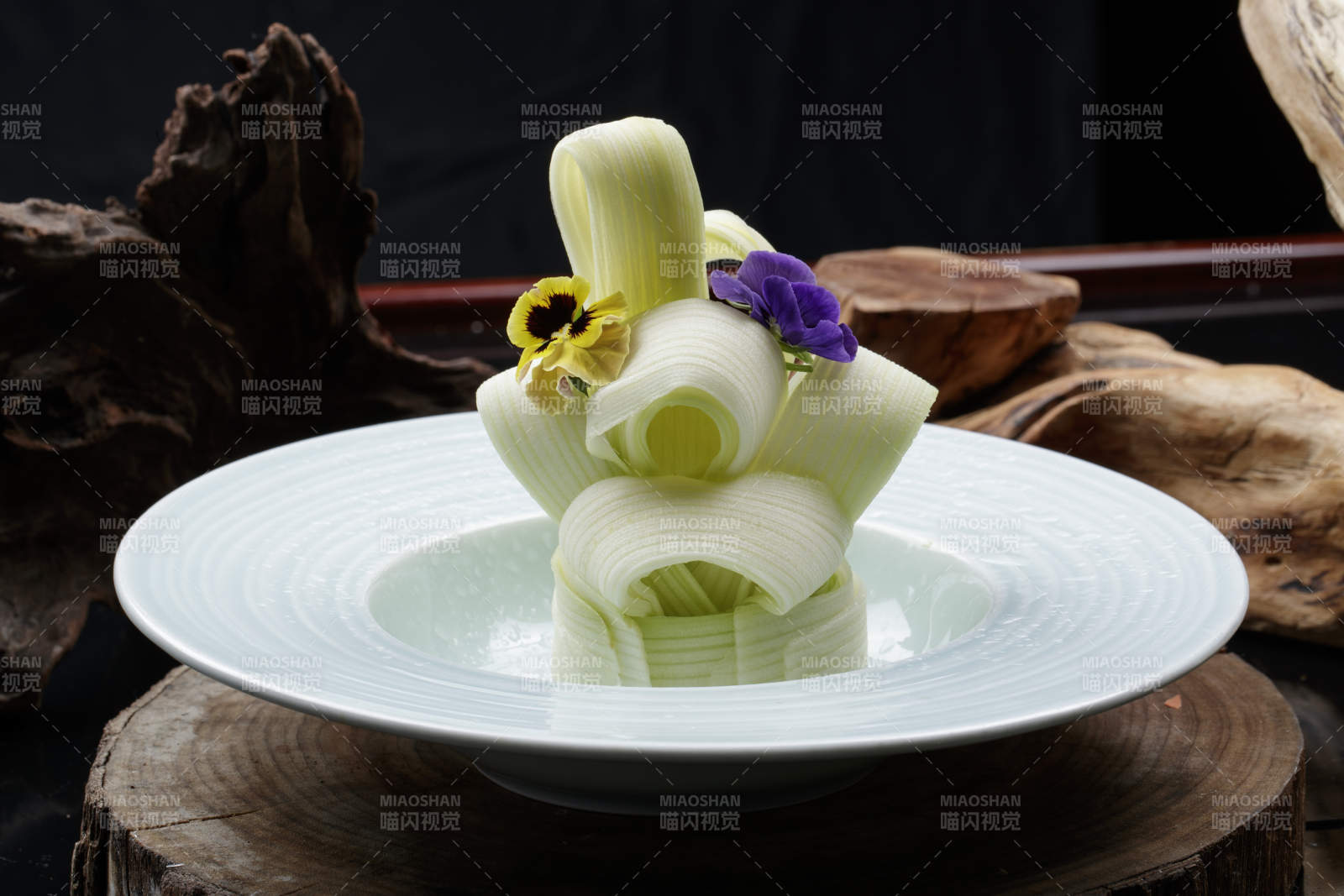 青瓷盘装的蘸汁西芹丝摆放在樟木砧板上图片