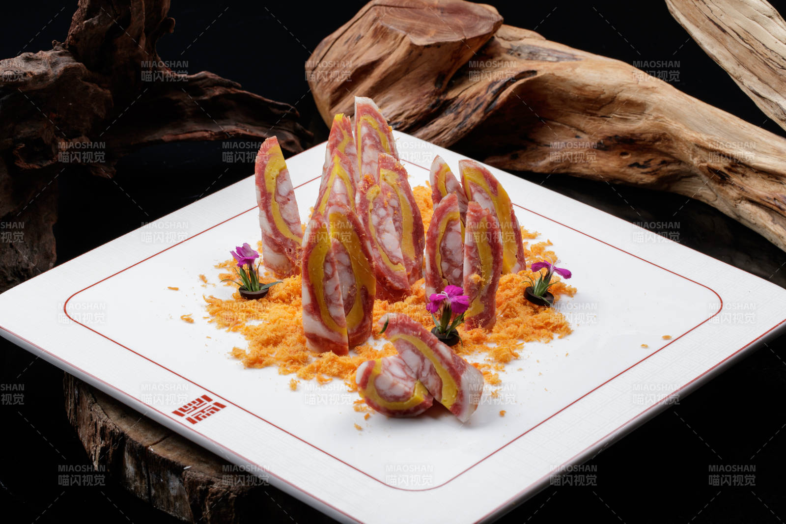 寿司帘上的扇形瓷盘装的自制川味腊肉香肠图片