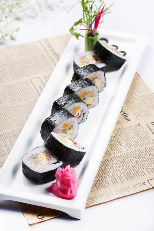 什锦太手卷寿司摆放在英文包装纸上图片