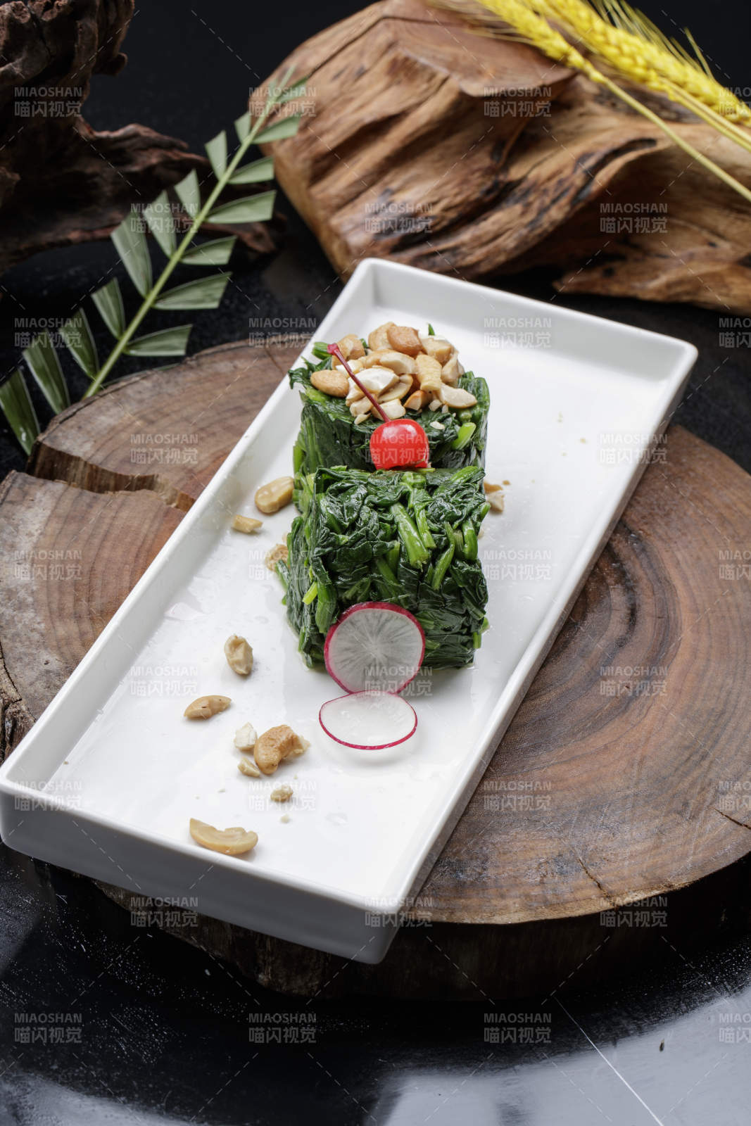 长方形瓷盘装的菠菜卷摆放在樟木砧板上图片