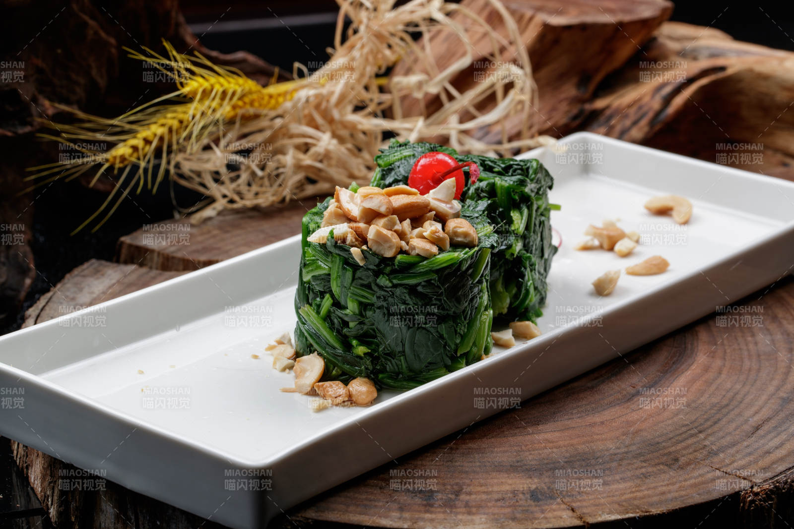 长方形瓷盘装的菠菜卷摆放在樟木砧板上图片