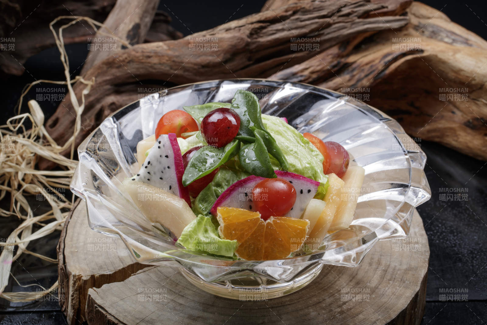 花纹玻璃碗装的果蔬拌菜摆放在樟木砧板上图片