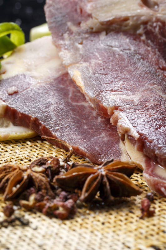 黑色背景草垫上的T骨牛排配柠檬图片