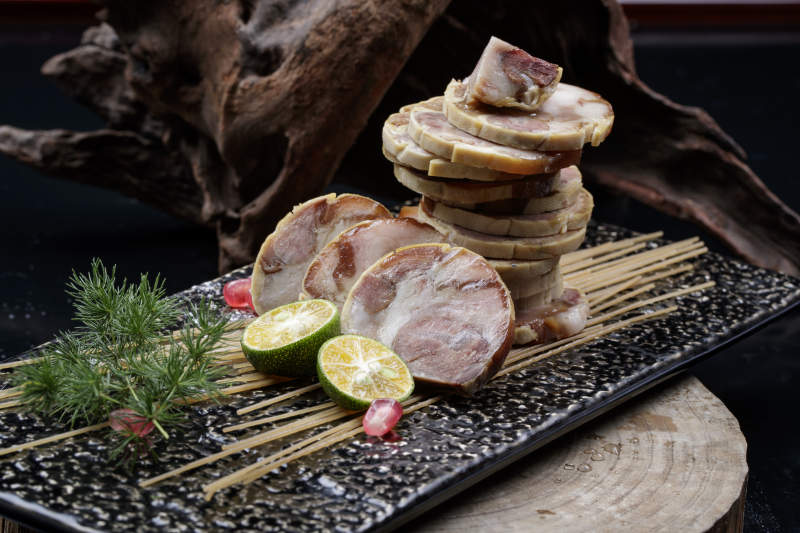 烟熏豆皮肘花卷摆放在樟木砧板上图片