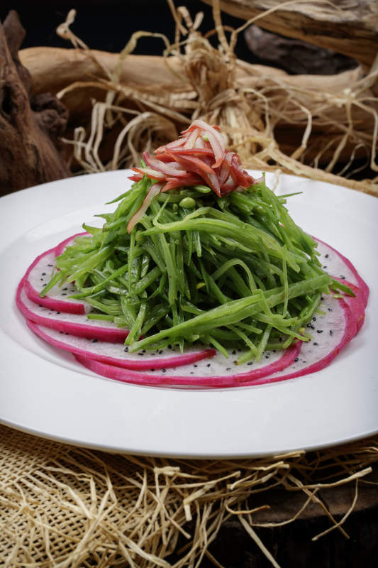 圆形瓷盘装的火龙果青瓜苗摆放在麻布垫子上图片