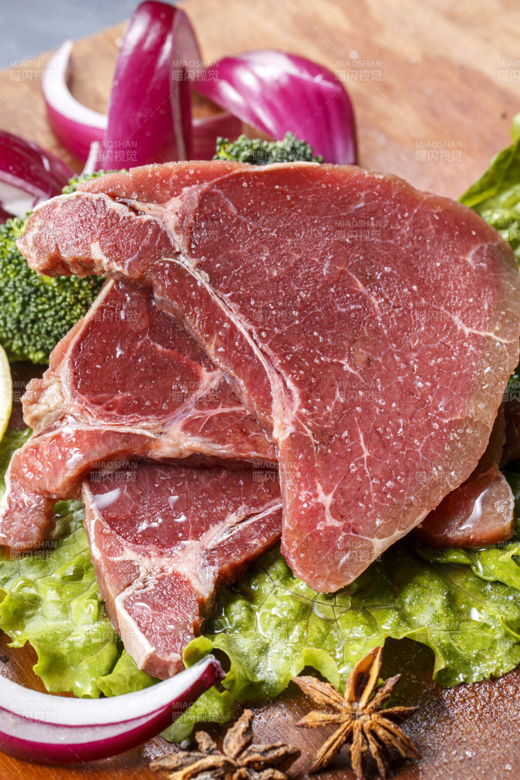 搭配洋葱生菜的牛米胧脍摆放在木质砧板上图片