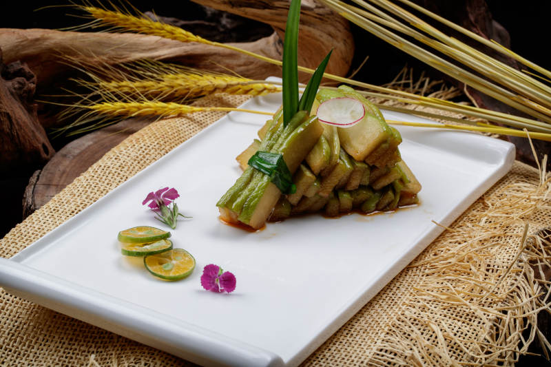 白色瓷盘装的腌渍酱佛手瓜切片图片