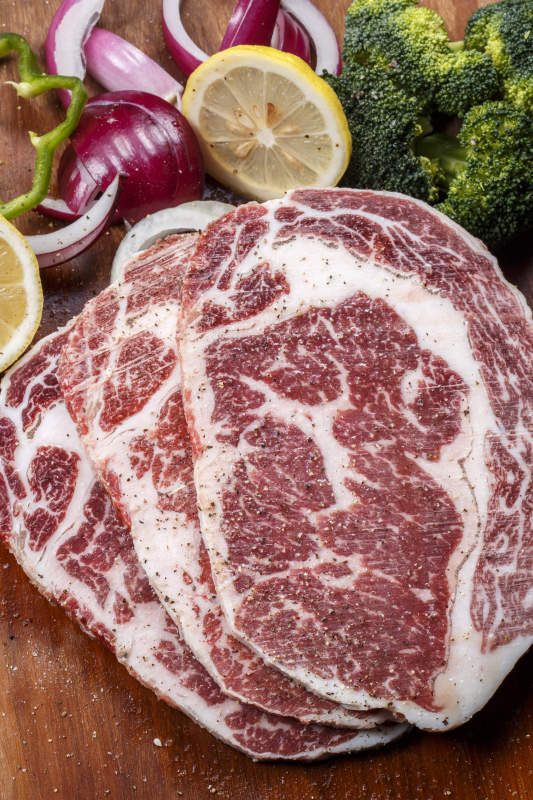 牛眼肉摆放在木质砧板上图片