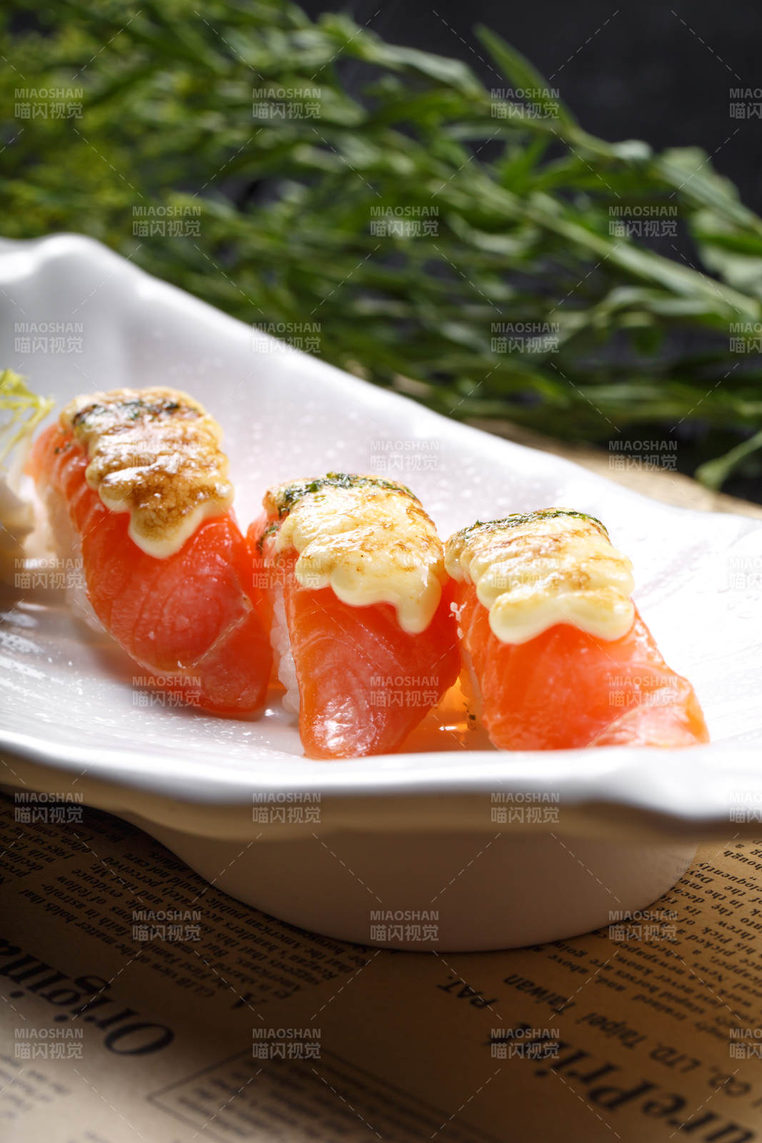 芝士焗三文鱼手握寿司摆放在英文包装纸上图片