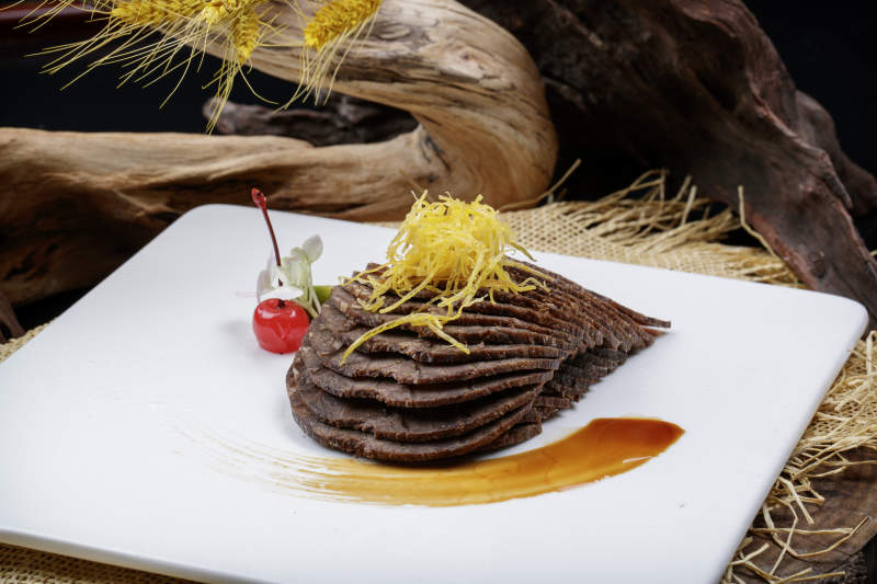 方形瓷盘装的五香酱牛肉摆放在麻布垫子上图片