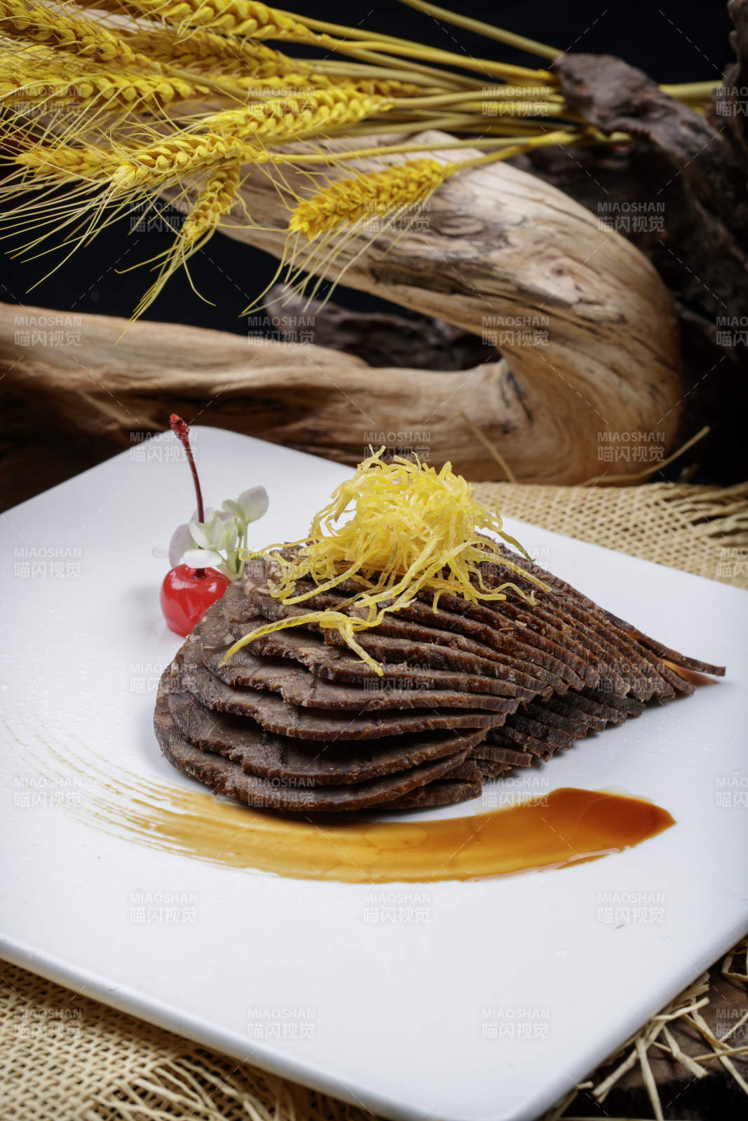 方形瓷盘装的五香酱牛肉摆放在麻布垫子上图片