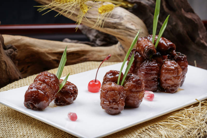 烟熏蜜汁带鱼卷摆放在麻布垫子上图片